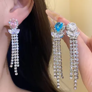 Close-up of sparkling zirconia teardrop dangle earrings with long rhinestone fringe