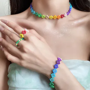 Detailed shot of Bohemian rainbow beaded flower jewelry set on model's neck and hand