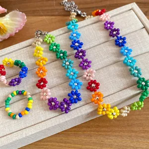 Close-up detail of colorful bohemian handmade rice bead flower necklace and rings set