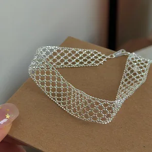 Macro view of a silver hollow mesh grid bracelet showing delicate woven texture detail