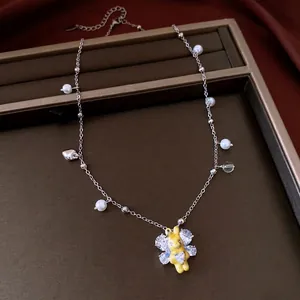 Silver pearl necklace with yellow rabbit pendant and crystal accents