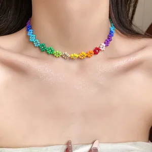 Detailed close-up of a bohemian rainbow flower seed bead choker necklace on a model