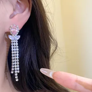 Close-up detail of elegant pink zircon waterdrop earrings with long rhinestone tassels