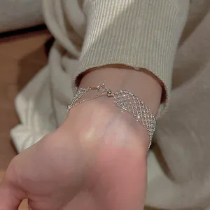 Close-up detail of minimalist hollow grid silver-toned mesh bracelet worn on a wrist