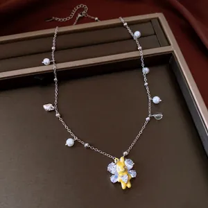 Detailed view of the yellow rabbit pendant necklace with pearls and zircon wings