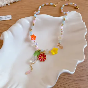 Primo piano di una collana di fiori dopamina colorati con perline e ciondoli su un piatto a conchiglia