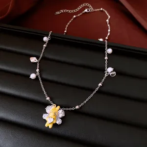 Detailed shot of a delicate yellow rabbit pendant with zircons on a pearl necklace