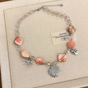 Detailed view of pink shell necklace with starfish and seashell silver charms