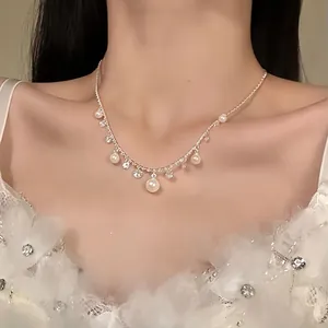 Close-up of elegant pearl and zircon necklace worn on collarbone with floral lace dress