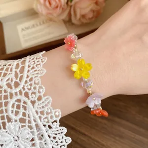 Elegante bracciale di perline con fiori in resina stile dopamina al polso da donna
