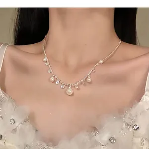 Close-up detail of an elegant pearl and zircon necklace worn by a model in lace dress