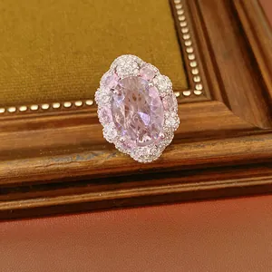 Dettaglio di un anello vintage di lusso con zircone rosa ovale e contorno di diamanti.
