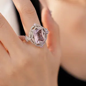 Dettaglio ravvicinato di un anello in stile palazzo con un grande zircone rosa sul dito.
