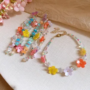 Primo piano di un set coordinato di bracciale e orecchini con fiori di resina colorati.