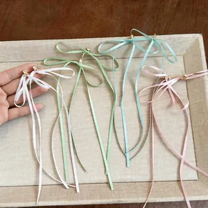 Vue détaillée de longues boucles d'oreilles nœud en ruban aux couleurs pastel