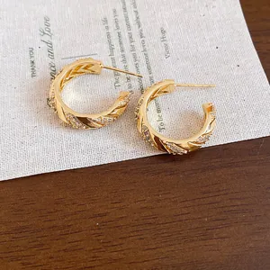 Close-up detail of 14k gold plated wheat pattern hoop earrings with sparkling zircon