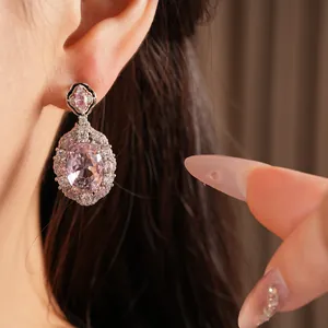 Primo piano di orecchini a goccia in zirconia rosa con dettagli squisiti in stile palazzo.