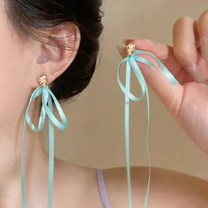 Vue détaillée d'élégantes boucles d'oreilles ruban vert menthe avec clous dorés