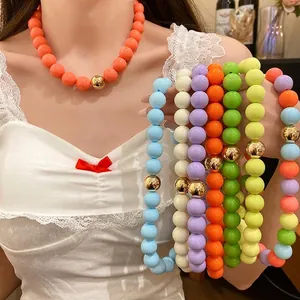 Chunky colorful round bead necklace set with central gold accent bead.