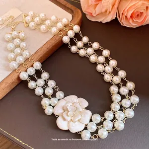 Vintage French multi-layer pearl necklace featuring elegant white enamel camellia flower