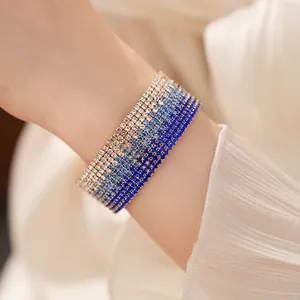 Elegant detail of a multilayer gradient blue rhinestone stretch bracelet worn on wrist