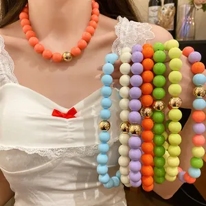 Detailed view of colorful chunky beaded jewelry set with gold beads on a female model