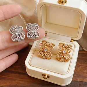 Elegantes pendientes de botón florales calados con circonitas en tonos plata y oro
