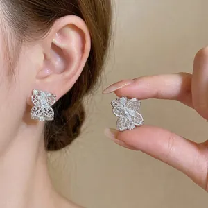 Elegantes pendientes de botón en forma de C de flor de plata con diseño hueco y circonitas