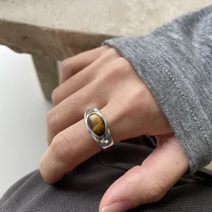 Detailed view of a silver open ring featuring an elegant brown oval resin stone.