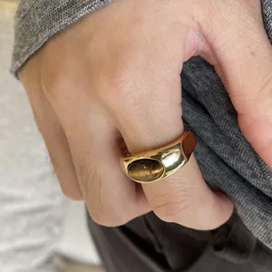 Detailed close-up of a vintage gold chunky ring featuring a brown oval resin stone