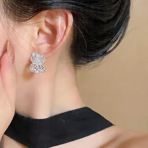 Primer plano de un elegante pendiente de mariposa plateado con circonitas en la oreja