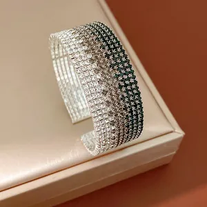 Close-up detail of a sparkling ombre multi-row rhinestone cuff bracelet on a beige jewelry box