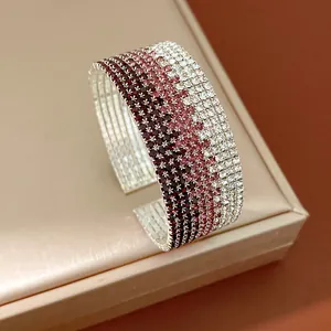 Close-up of a multi-layer gradient rhinestone cuff bracelet with pink and white stones.