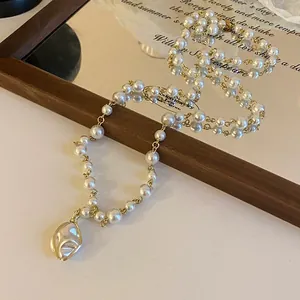 Detailed macro shot of vintage baroque pearl necklace with irregular pendant on a mirror