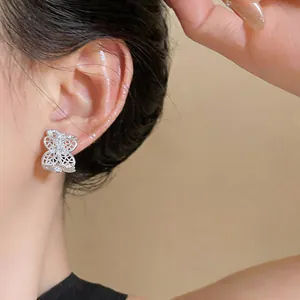 Vista detallada de pendientes de botón de mariposa de plata con circonitas brillantes
