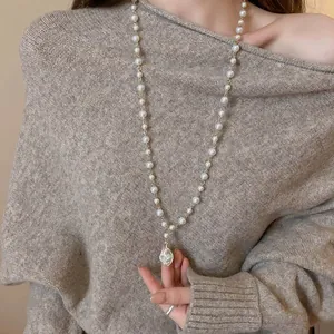 Detailed view of long faux pearl necklace with an elegant irregular baroque pendant