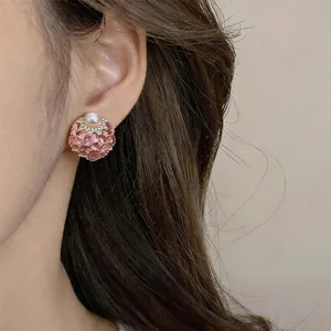 Close-up of vintage pink gemstone and pearl stud earring on an Asian model's ear