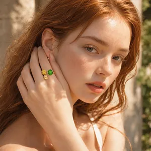 Gold-plated open ring with green and yellow geometric gemstones shown on a female model's finger