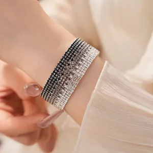 Detail of a multi-layer gradient rhinestone bracelet with black and silver stones