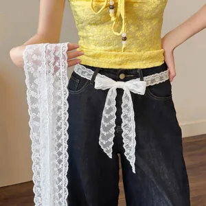 White floral lace long ribbon scarf used as a stylish belt decoration on black jeans