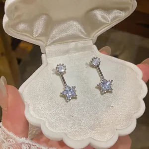 Detailed view of elegant silver-toned star zircon drop earrings in a white shell box