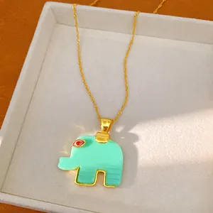 Close-up of a bohemian resin elephant pendant necklace with gold chain in a jewelry box