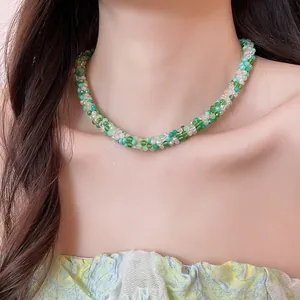 Detail of handcrafted braided green crystal bead necklace on model neck