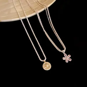 Macro view of dainty double-layered necklace with sparkling zirconia flower pendant