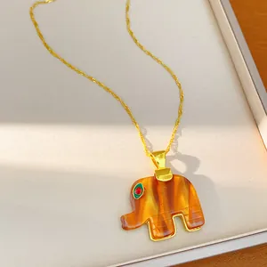 Macro detail of bohemian style amber-toned resin elephant pendant necklace accessory