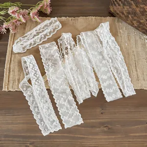 Detailed shot of several white floral lace ribbons showing delicate embroidery designs