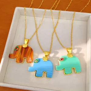 Detailed view of three resin elephant pendant necklaces in brown, blue, and mint green.