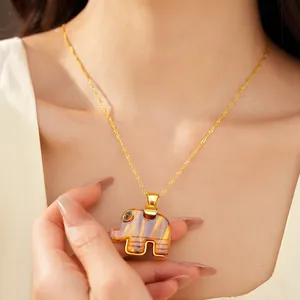 Detail view of a Bohemian resin elephant pendant necklace on a gold water wave chain