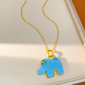 Detailed view of a bohemian blue resin elephant pendant on a gold chain necklace.