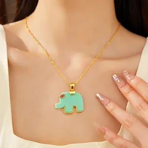Close-up detail of a minimalist green resin elephant pendant necklace on a female model.